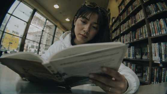 A reader examines a book at a library table