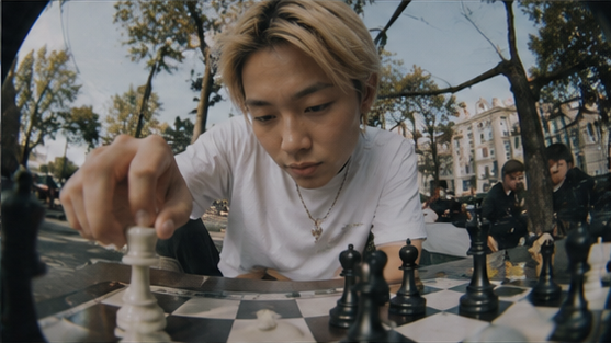 A player moves a chess piece in a city park